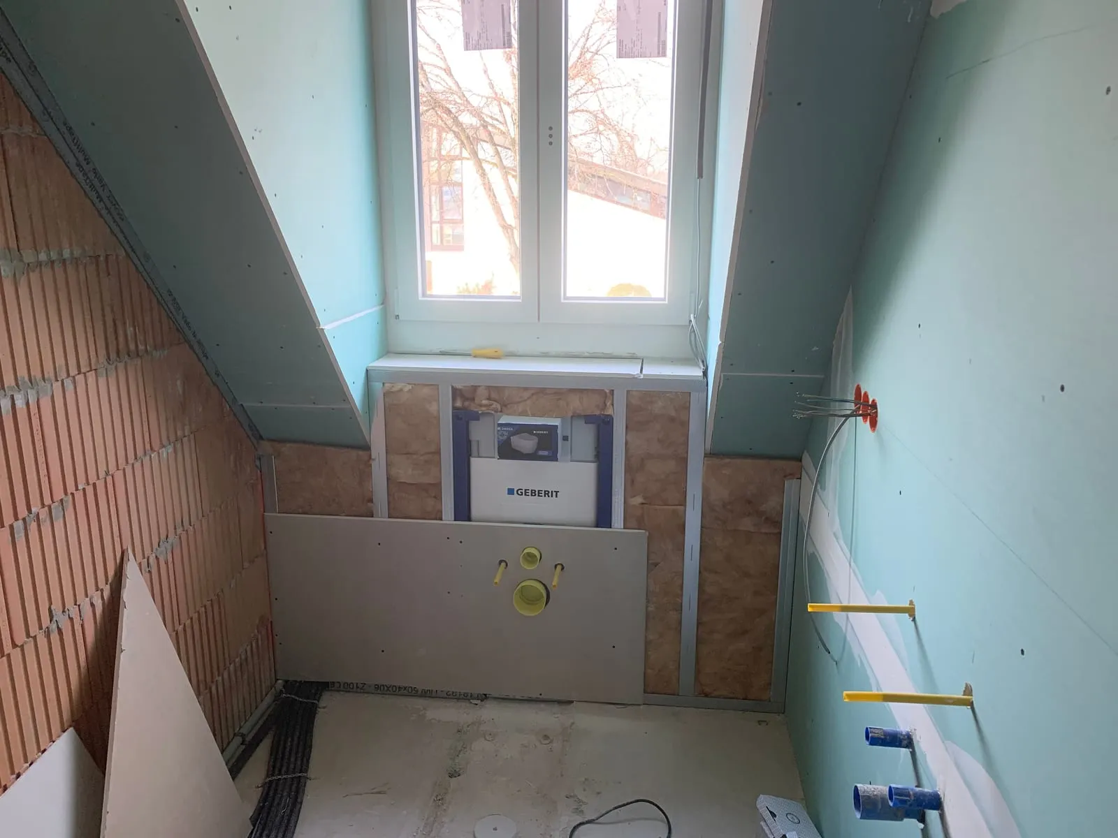 Badezimmer im Rohausbau mit grünen imprägnierten Gipsplatten und gedämmter Fensternische
