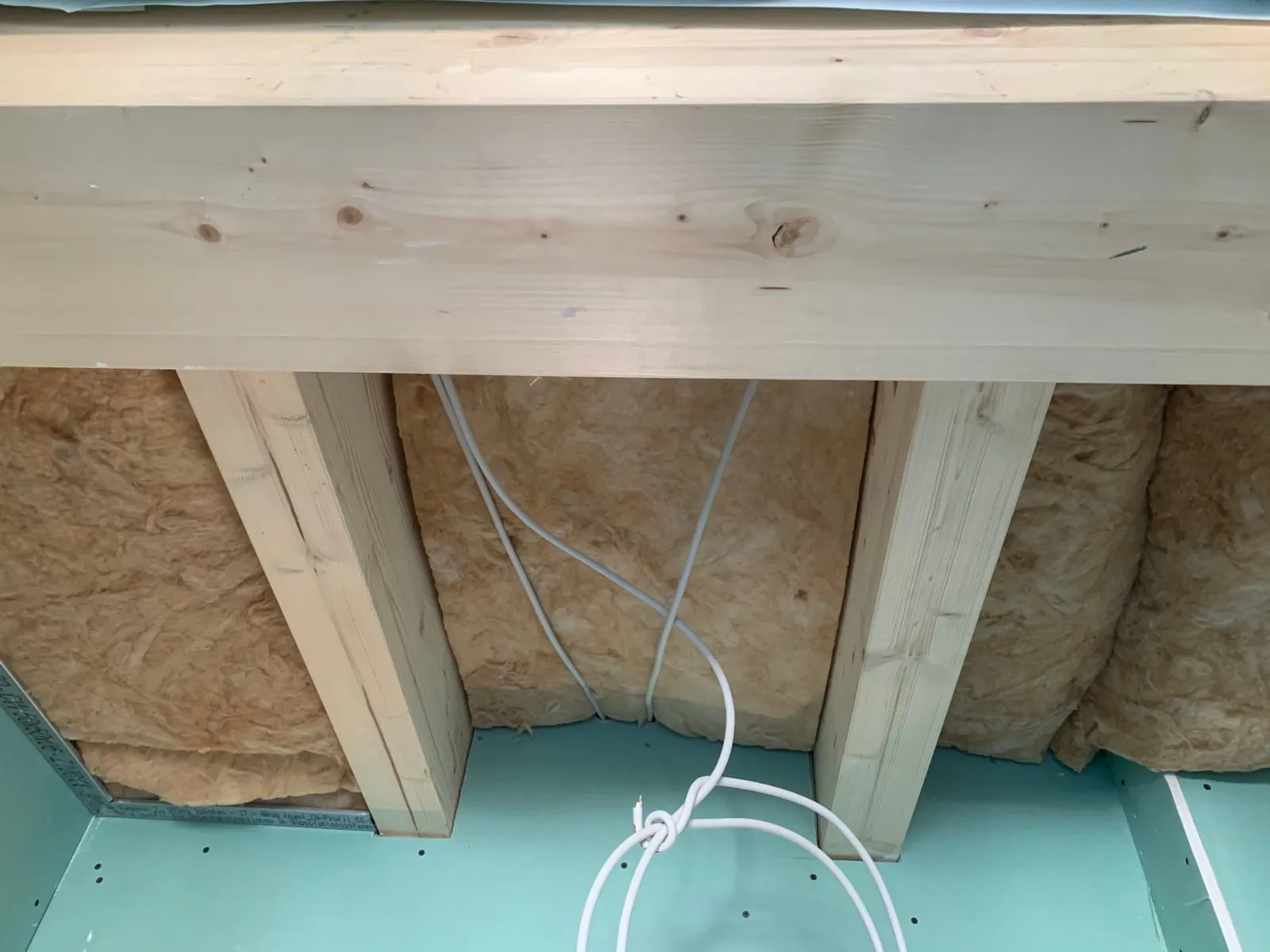 Mineralwolldämmung zwischen Holzsparren, erste imprägnierte Platten an der Schräge montiert