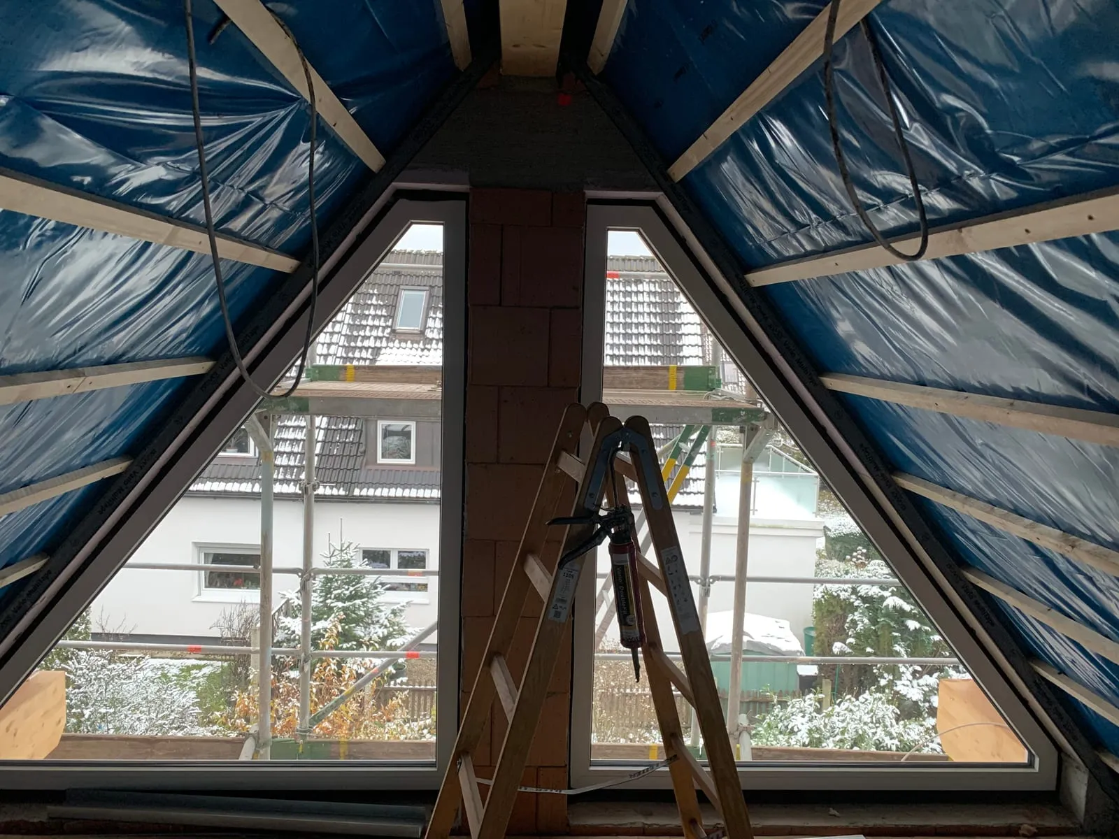 Giebelfenster im Dachgeschoss mit verlegter blauer Dampfbremsfolie an den Schrägen